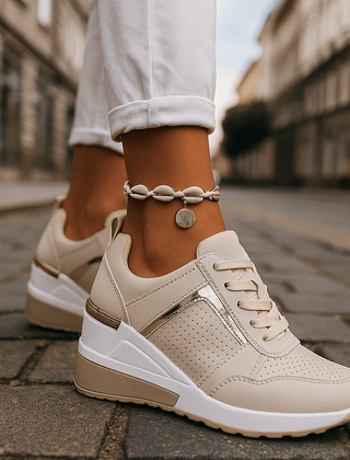 Beige lace-up sneakers with perforated toe and cushioned white sole.