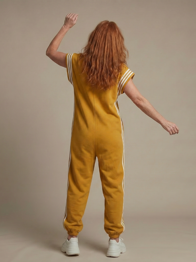 Mustard yellow back view zip-front jumpsuit with white stripe sleeves and side stripes