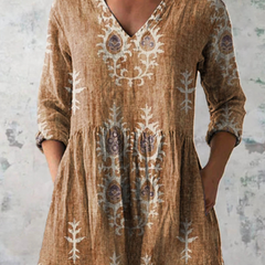 Tan long-sleeve V-neck embroidered blouse with gathered waist and folk floral details