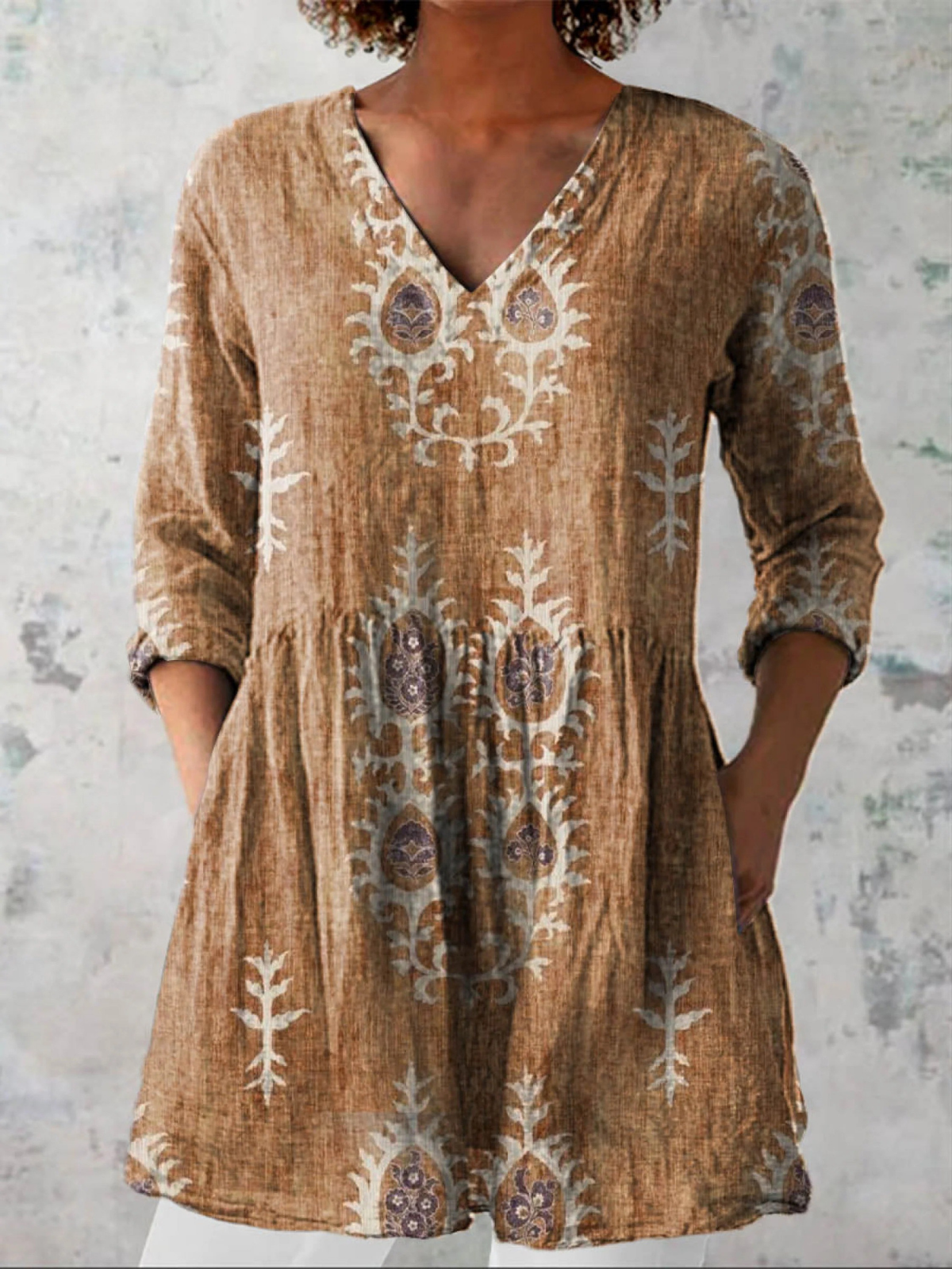 Tan long-sleeve V-neck embroidered blouse with gathered waist and folk floral details