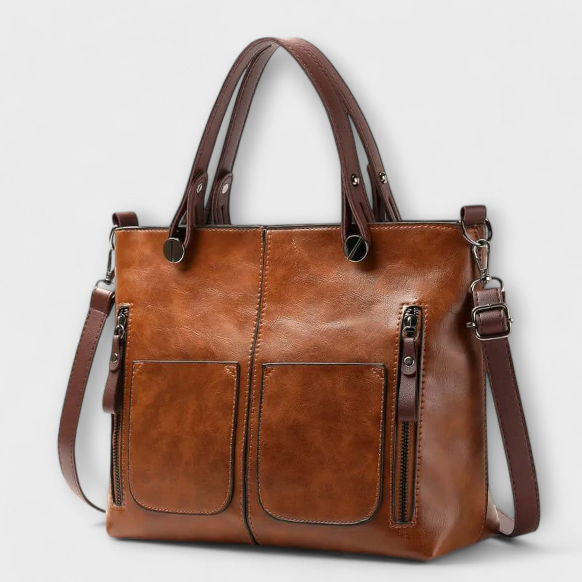 Brown leather tote bag with top handles, front pockets, and side zip details.