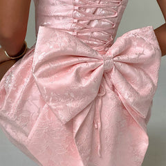 Pink jacquard mini dress close-up of corset lacing and voluminous bow-knot skirt