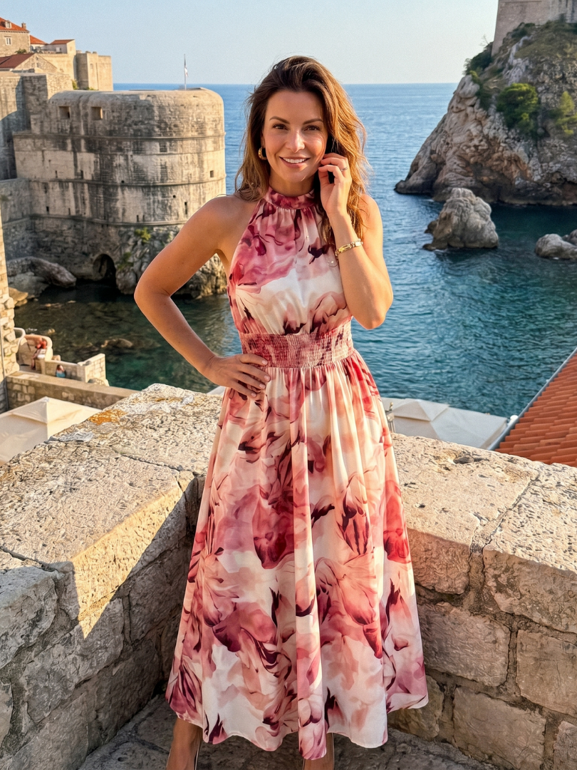 Pink/red abstract print gathered-waist midi dress with sleeveless halter neckline, full length