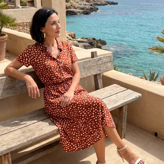 Red printed button-front belted midi dress sitting with short sleeves
