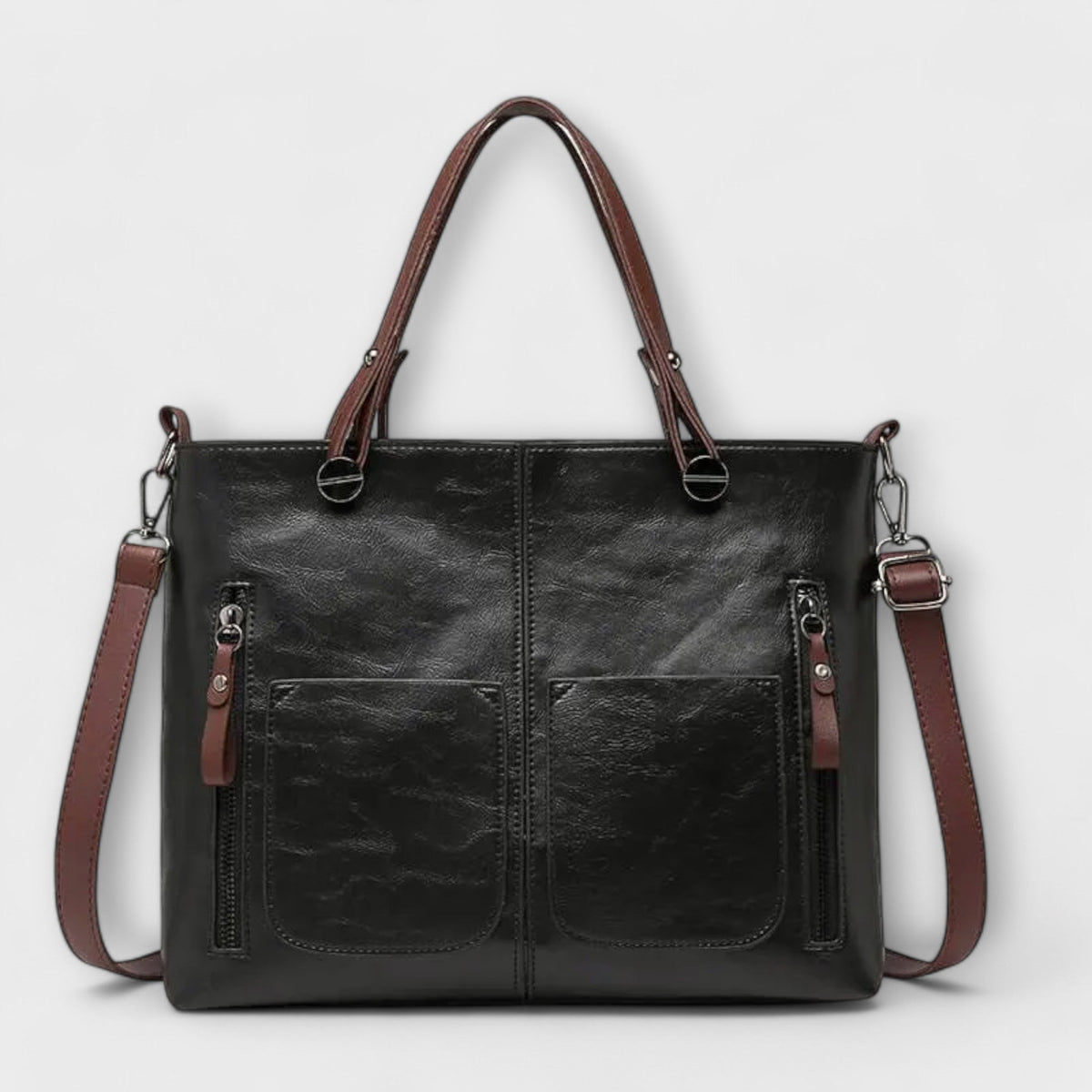 Black leather tote bag with top handles, front pockets, and long shoulder strap.