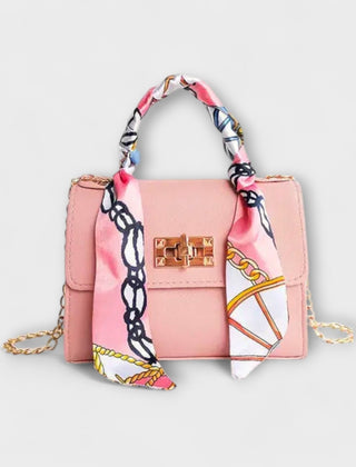 Pink handbag with gold clasp, chain strap, and multicolor patterned scarf