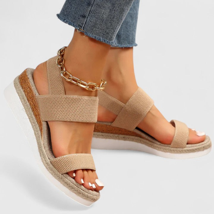 Orthopedic sandals in tan fabric with wide straps and gold chain ankle bracelet