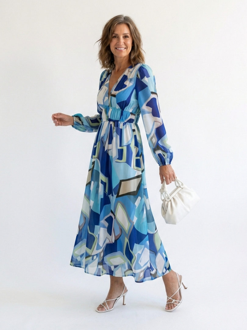 Althea long-sleeve graphic maxi dress with V-neck and gathered waist, blue tones; holding bag