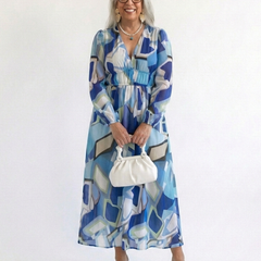 Althea long-sleeve graphic maxi dress with gathered waist and V-neck, blue multi-color; holding bag