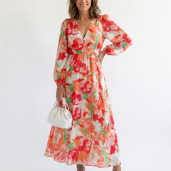 Althea long-sleeve floral maxi dress with V-neck and tiered skirt, orange; holding mini bag
