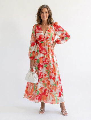 Althea long-sleeve floral maxi dress with V-neck and tiered skirt, orange; holding mini bag