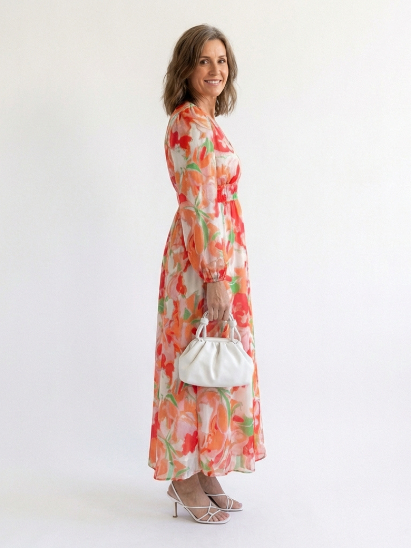Orange floral maxi dress with V-neck, long sleeves, tiered ruffle skirt, side view