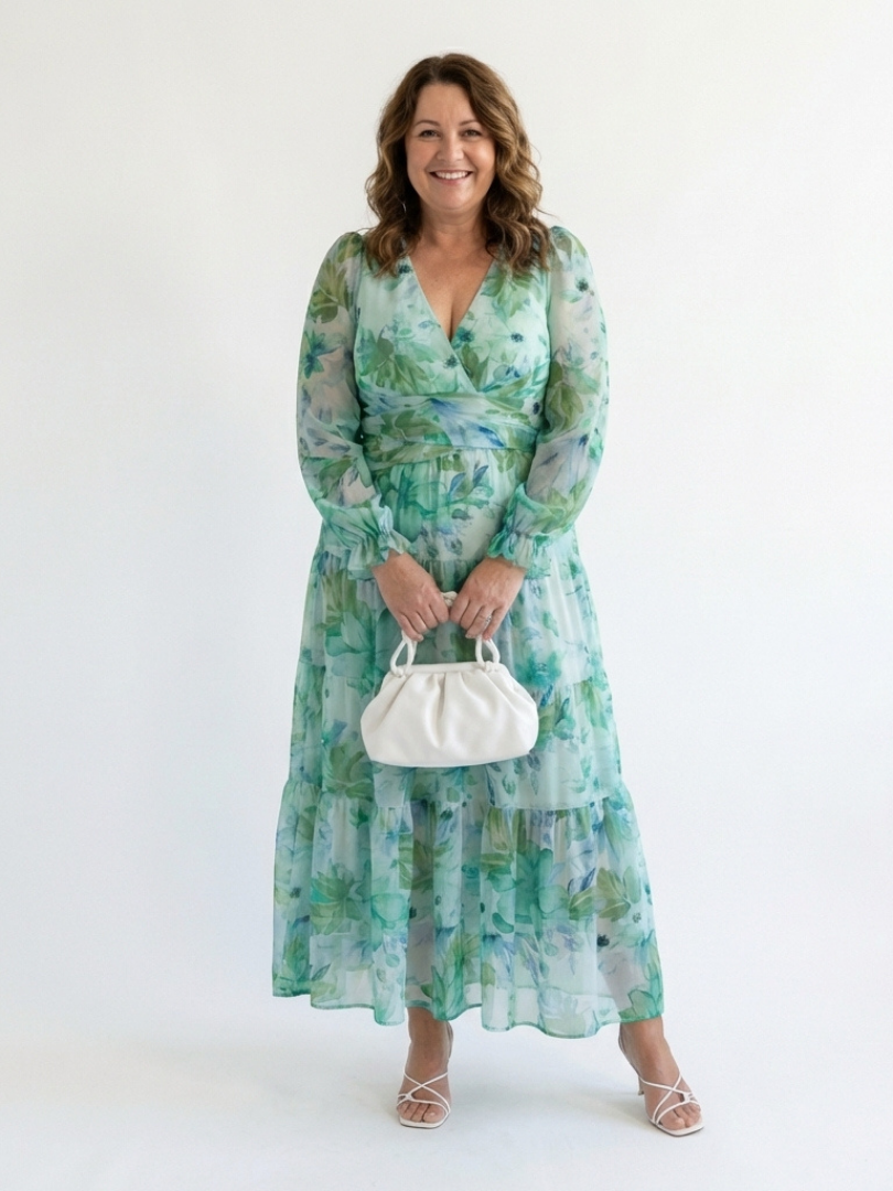 Althea long-sleeve floral maxi dress with gathered waist, tiered hem, green; holding mini bag