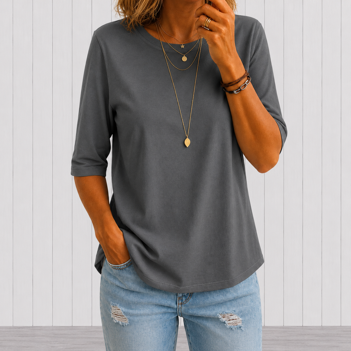 Grey crewneck comfort tee with 3/4 sleeves, draped fit, and rounded hem