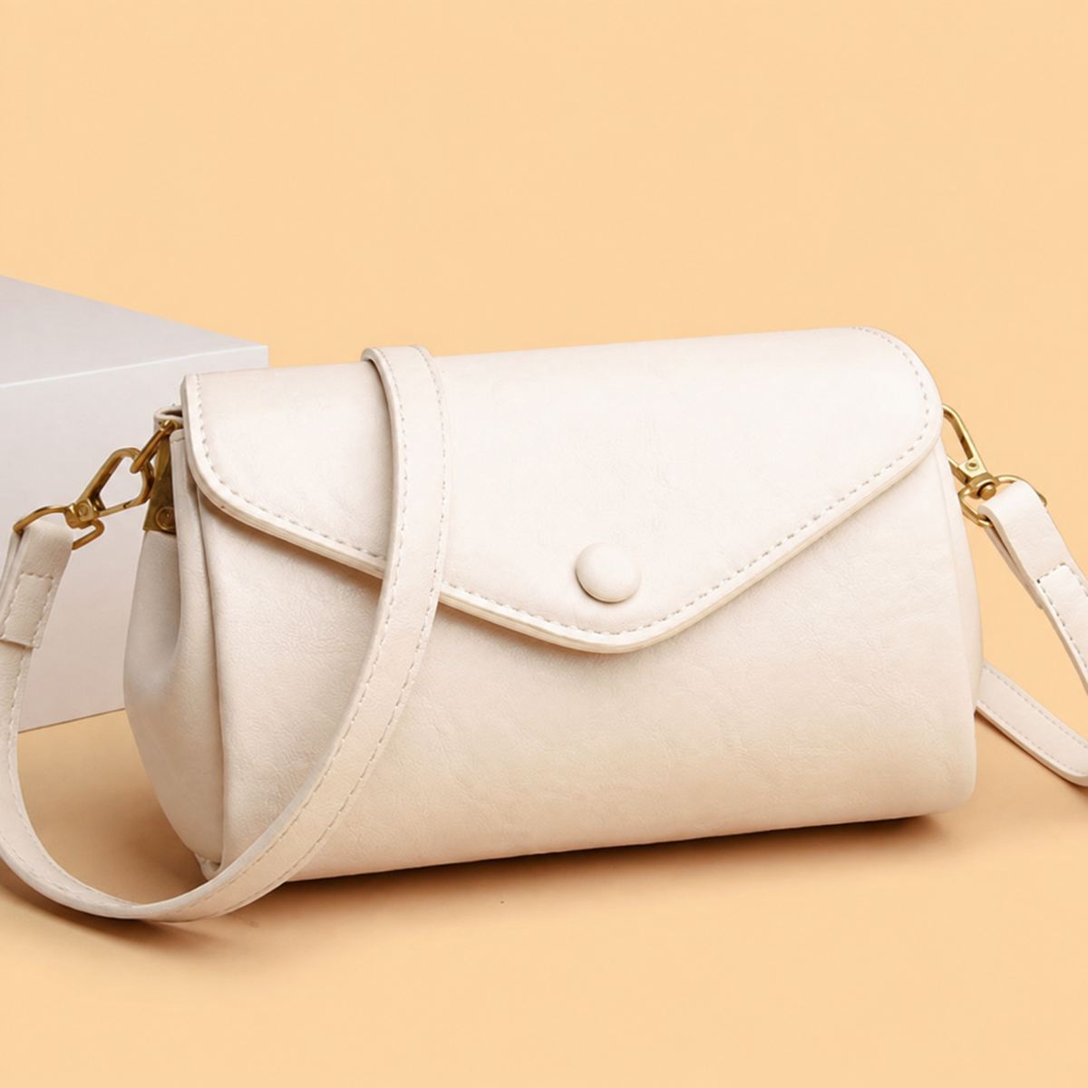 White classic crossbody bag with flap, snap button, and adjustable shoulder strap