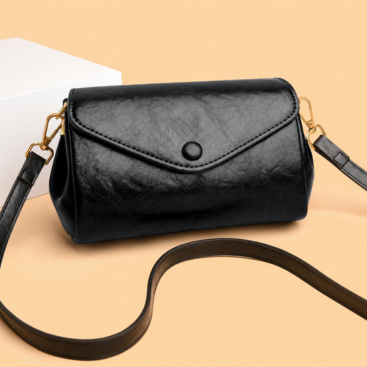 Black classic crossbody bag with front flap, snap button, and slim crossbody strap
