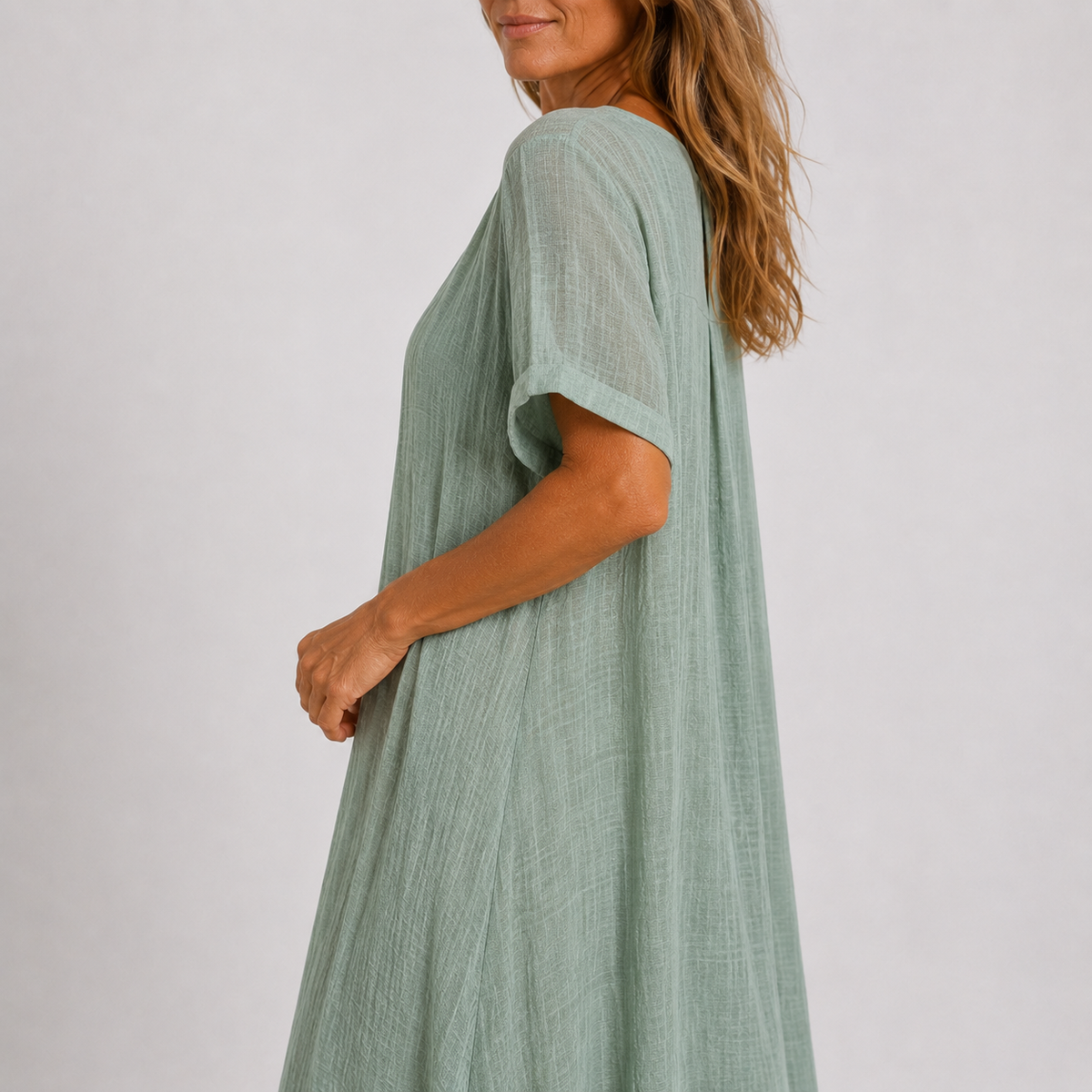 Green V-neck midi dress, short sleeves, side view with flowing A-line skirt