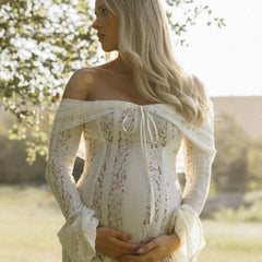 White lace maxi dress, off-shoulder neckline and long sleeves; fitted bodice, flowing skirt.