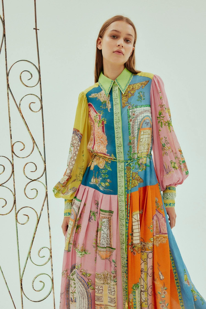 Multi-hued maxi dress with high collar, puff sleeves, and tiered skirt; front view.