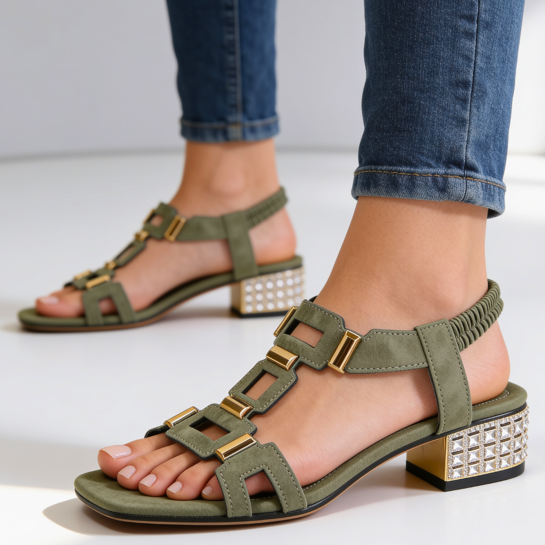 Green strappy sandals on feet with jeweled block heel and gold buckle details