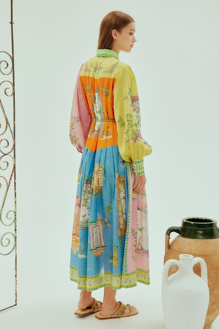 Multi-hued designer maxi dress with high collar, puff sleeves, and belt; back view.