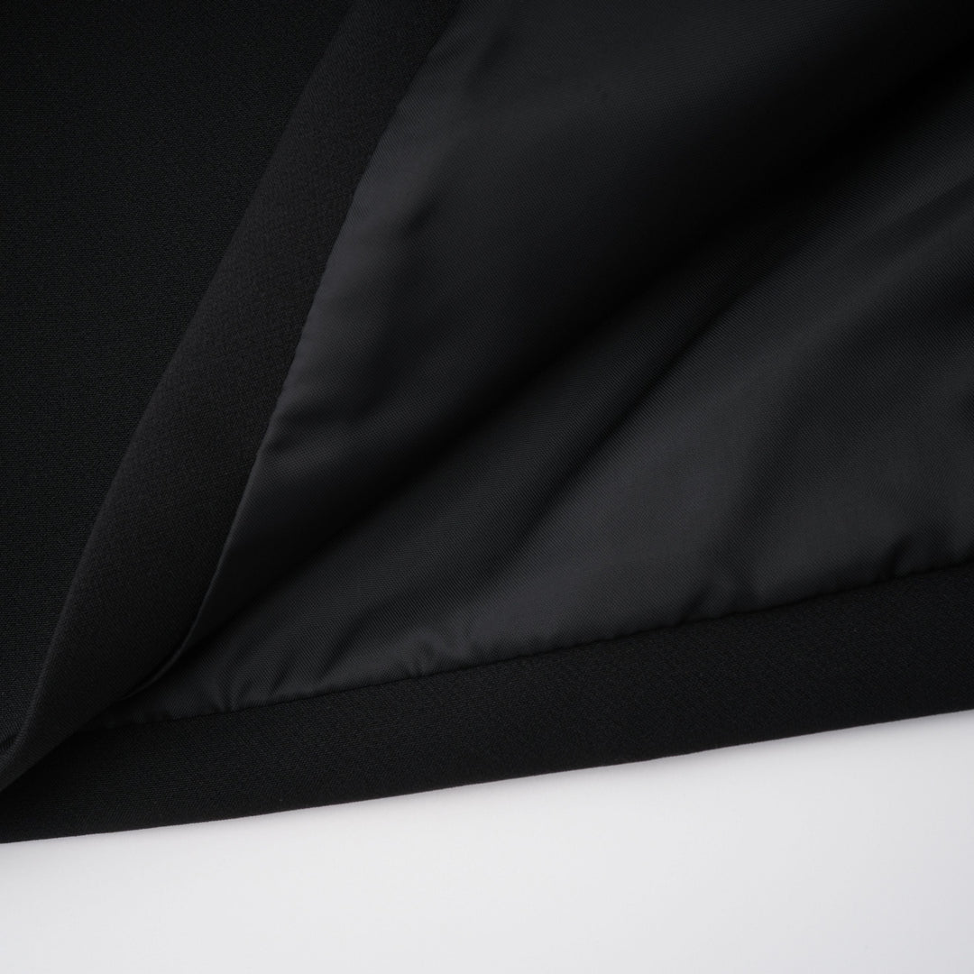 Black fabric close-up with soft drape and smooth, slightly shiny surface folds