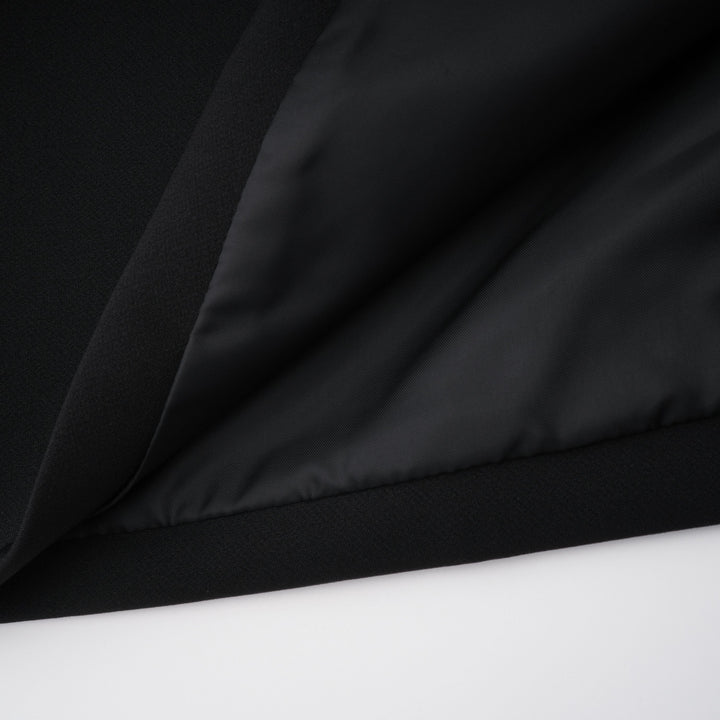 Black fabric close-up with soft drape and smooth, slightly shiny surface folds