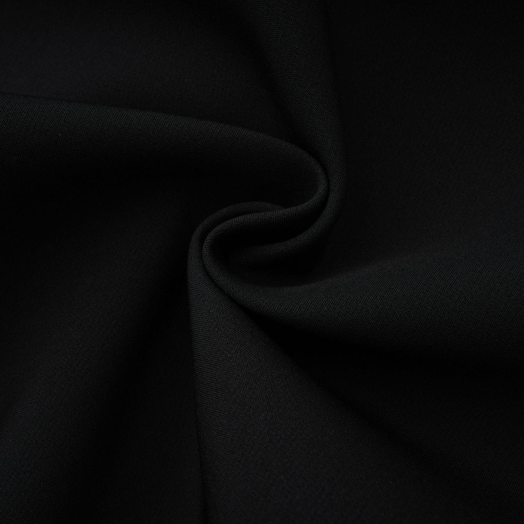 Black fabric close-up with gathered folds and fine woven texture