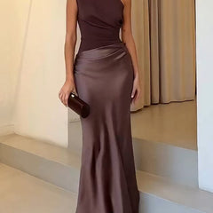 One-shoulder pleated satin maxi dress in dark brown with draped waist and fitted skirt.