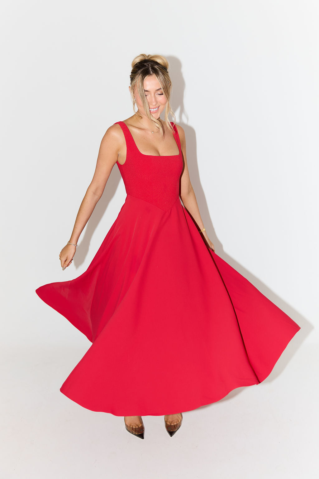 Red sleeveless midi flow dress with wide skirt and cinched waist seam