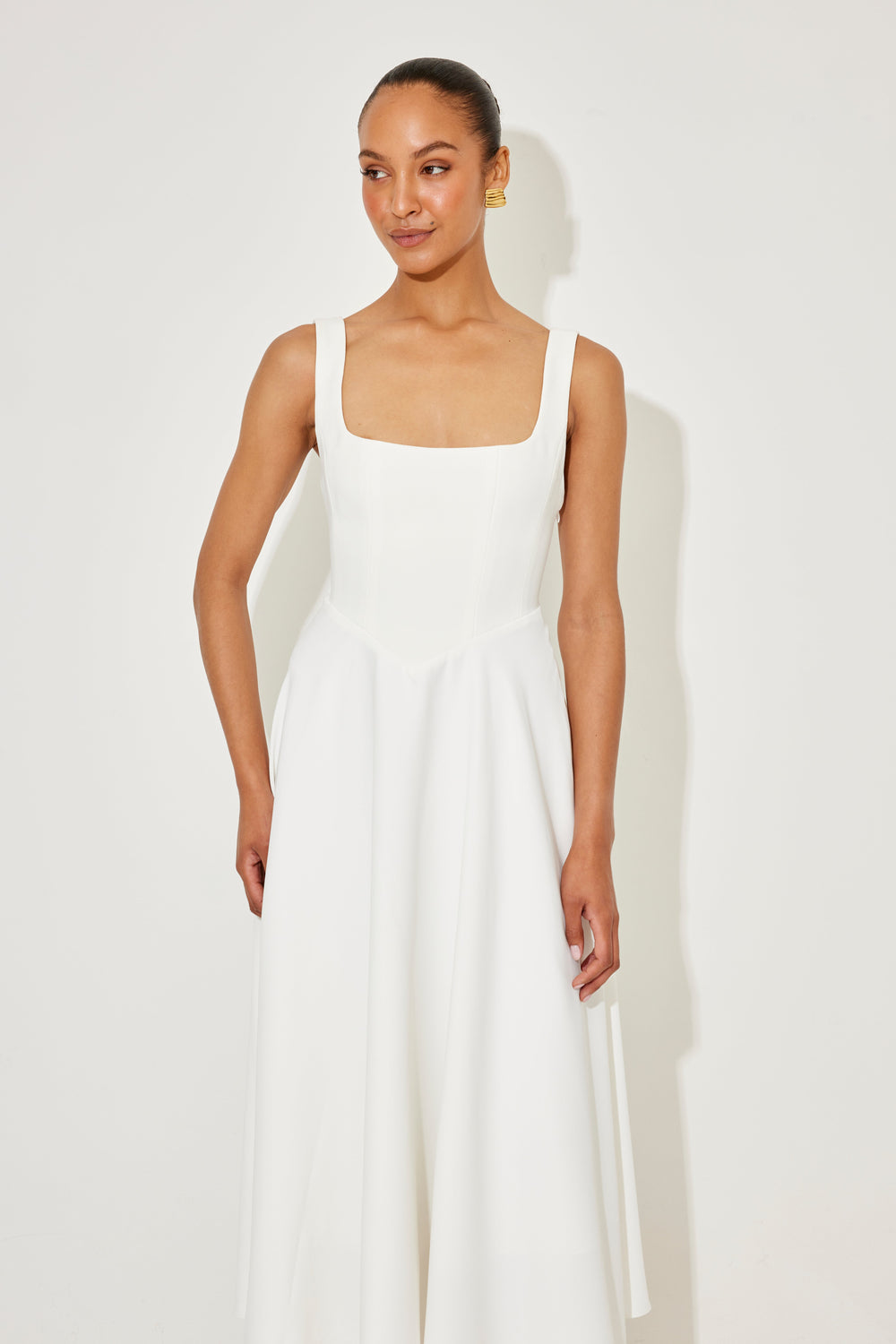 White midi flow dress with square neckline, fitted waist seams, and flared skirt