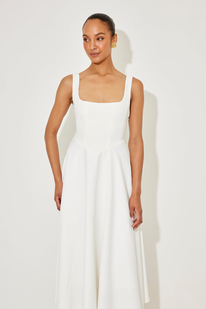 White midi flow dress with square neckline, fitted waist seams, and flared skirt