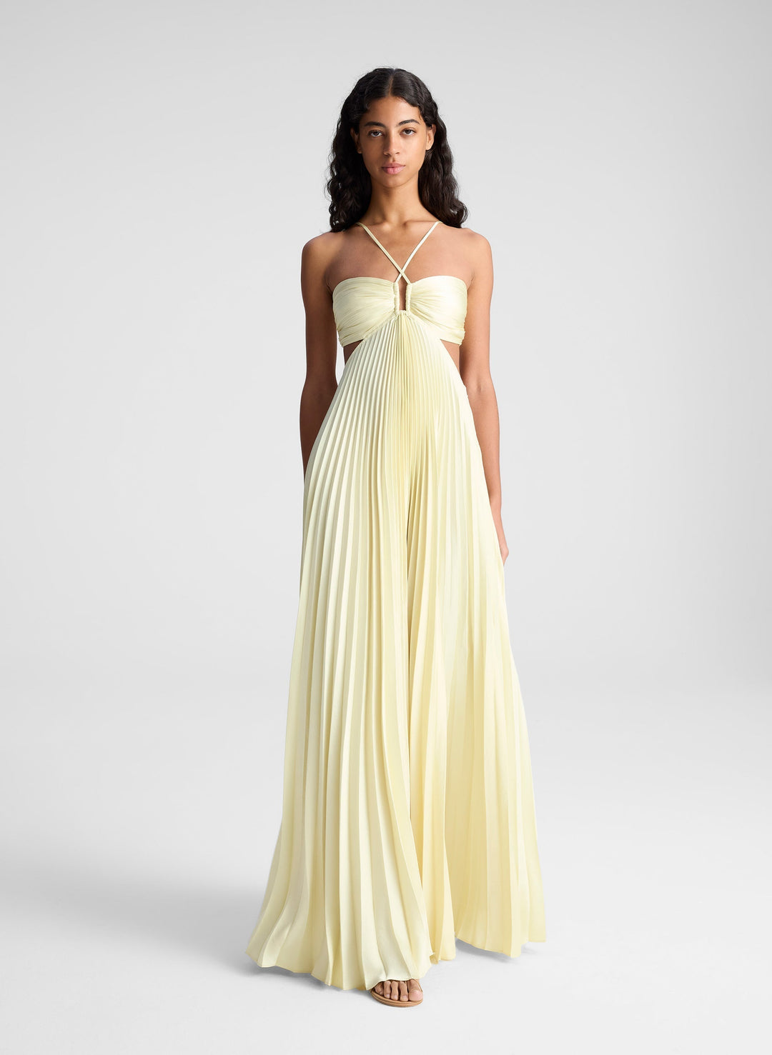 Pleated cut-out gown in pale yellow with spaghetti straps and draped bodice