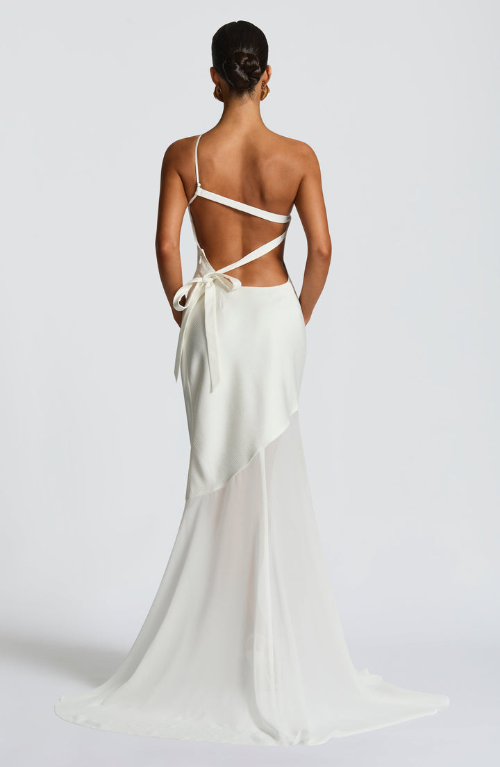 Ivory backless one-shoulder gown with crisscross straps and flowing train