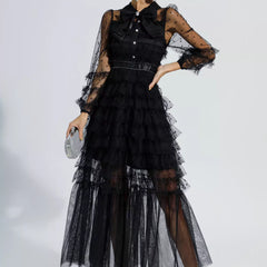 Black maxi dress with tiered tulle layers, sheer polka-dot sleeves, and belted waist
