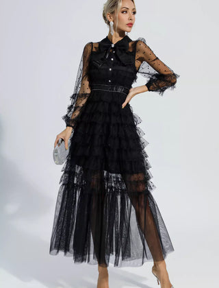 Black maxi dress with tiered tulle layers, sheer polka-dot sleeves, and belted waist