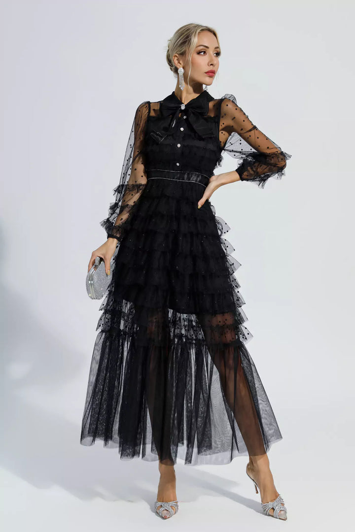 Black maxi dress with tiered tulle layers, sheer polka-dot sleeves, and belted waist