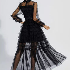 Black maxi dress viewed from back with tiered tulle skirt and sheer polka-dot sleeves