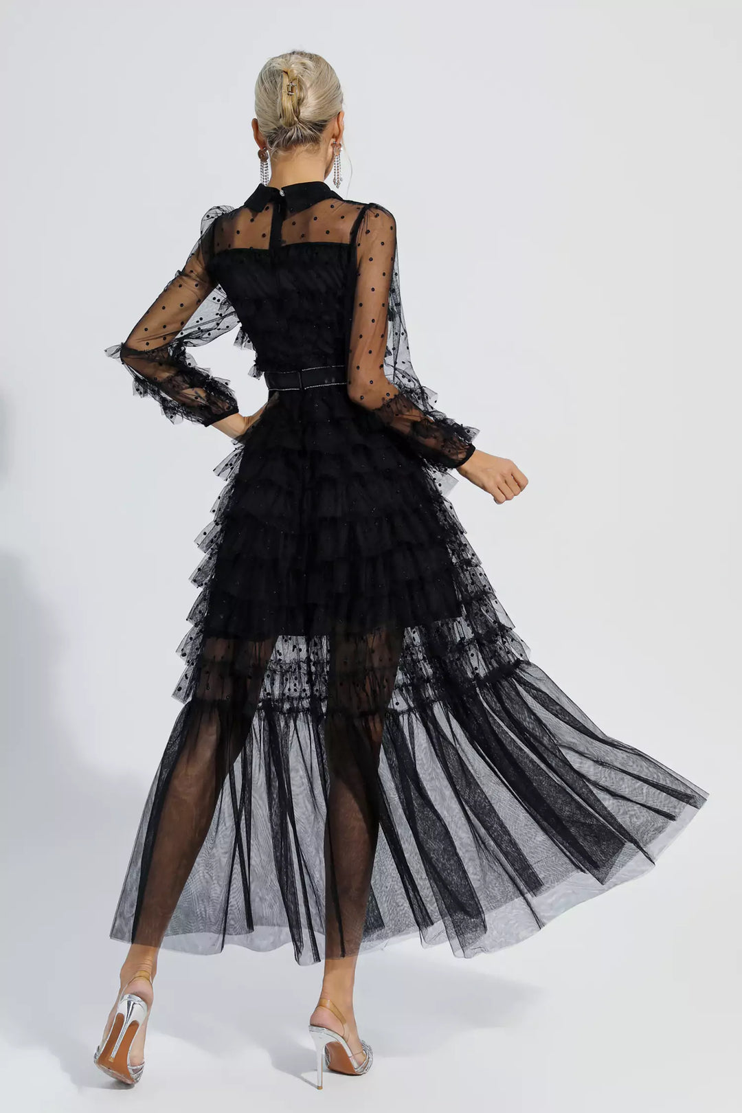 Black maxi dress viewed from back with tiered tulle skirt and sheer polka-dot sleeves