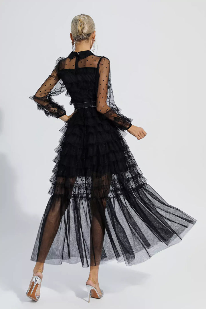 Black maxi dress viewed from back with tiered tulle skirt and sheer polka-dot sleeves