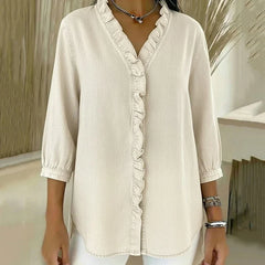 White denim blouse with ruffled V-neck and button-front placket, three-quarter sleeves