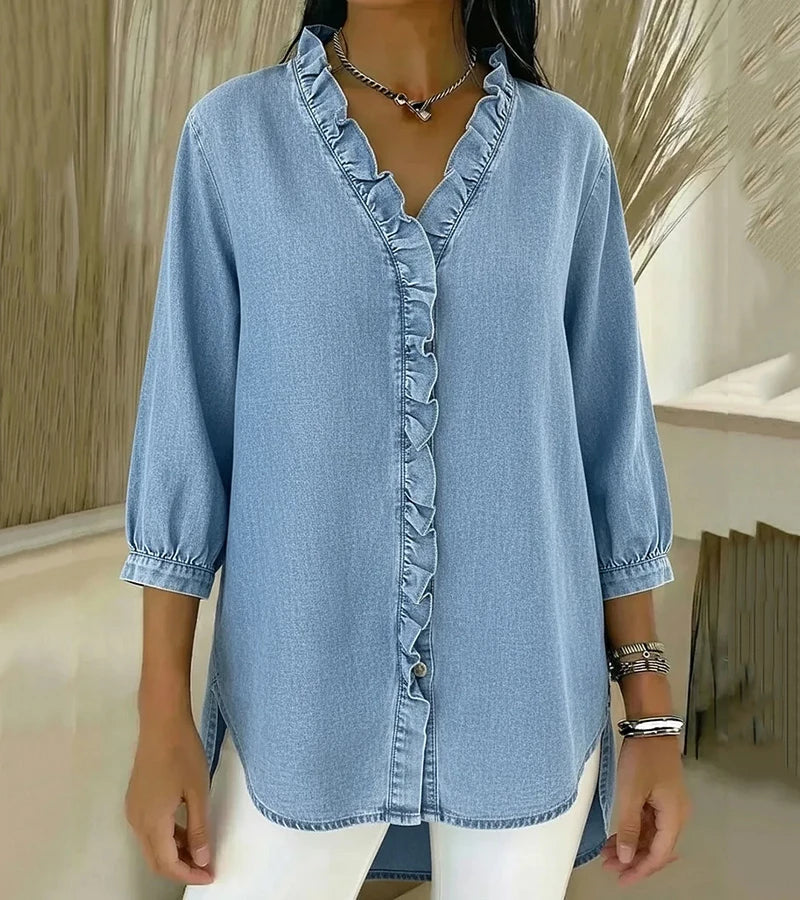 Light blue denim blouse with ruffled V-neck and button-front placket, three-quarter sleeves