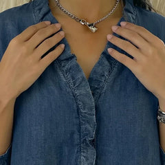 Blue denim blouse front detail: ruffled V-neck and button placket