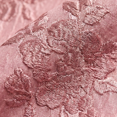 Close-up of pink floral textured fabric with embroidered pattern