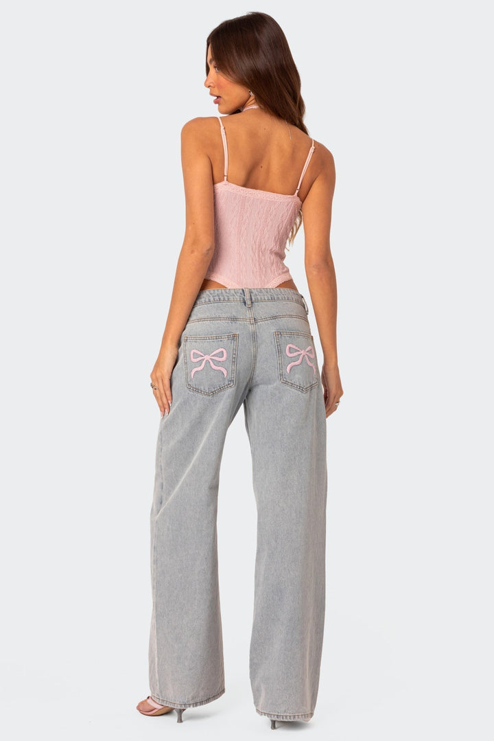 Light gray wide-leg jeans with pink bow embroidery on back pockets