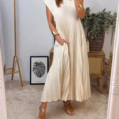 Beige sleeveless pleated maxi dress with round neck and short cap sleeves.