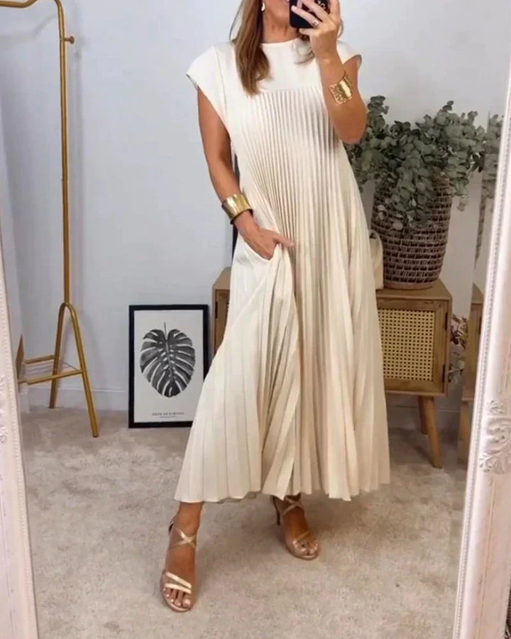 Beige sleeveless pleated maxi dress with round neck and short cap sleeves.