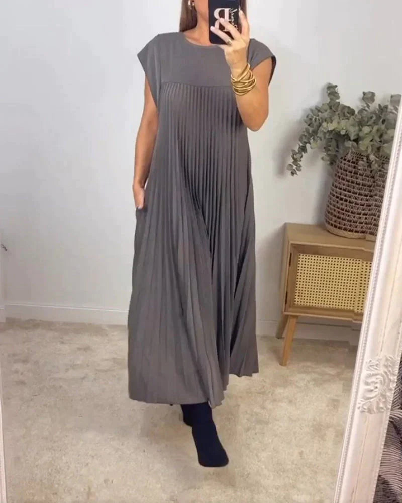 Gray sleeveless pleated maxi dress with round neck and vertical pleats.