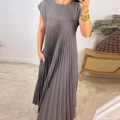 Gray sleeveless pleated maxi dress with round neck and flowing pleat skirt.