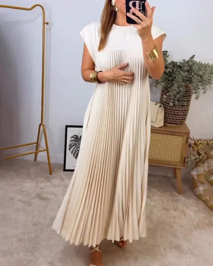 Cream sleeveless pleated maxi dress with round neck and vertical pleats.